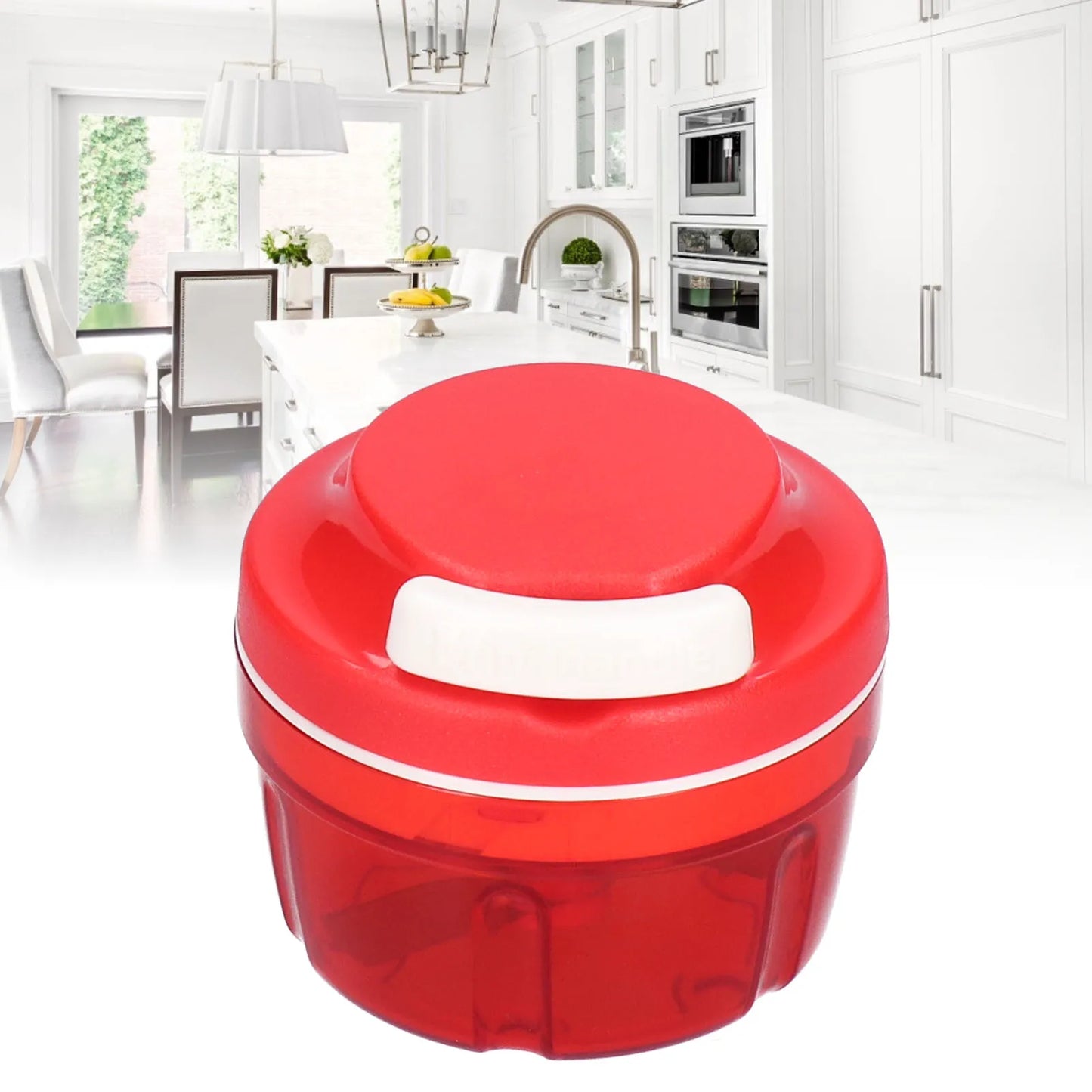 Red manual food chopper with a white button on a white kitchen island in a bright modern kitchen