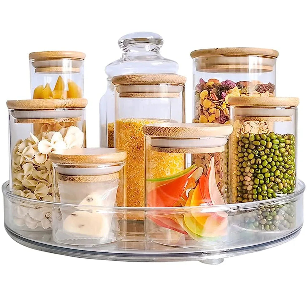 Clear glass jars with bamboo lids storing various dry foods on a clear rotating tray