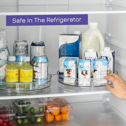 Hand reaching into refrigerator with rotating clear trays holding assorted drinks and cartons, fresh fruits below
