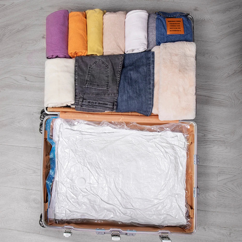 Open suitcase packed with neatly folded clothes and vacuum-sealed bags on wooden floor