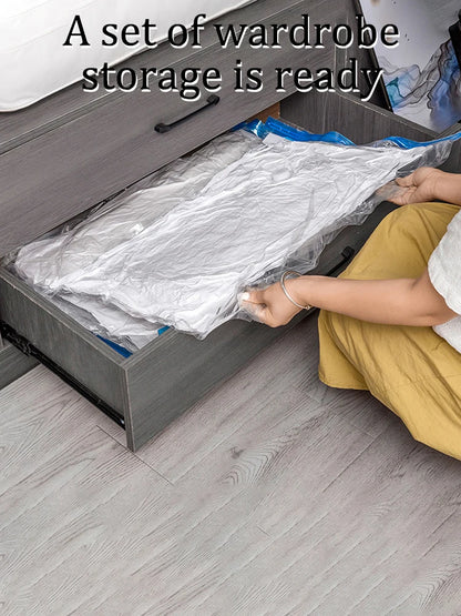 Person placing a vacuum-sealed clothes storage bag in a gray under-bed drawer on light wood flooring